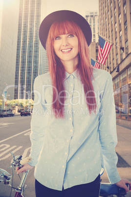 Composite image of smiling hipster woman leaning on a bike