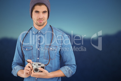 Composite image of portrait of confident  hipster using camera