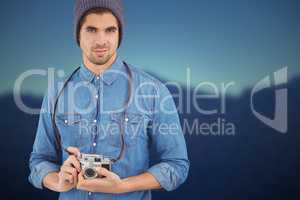 Composite image of portrait of confident  hipster using camera