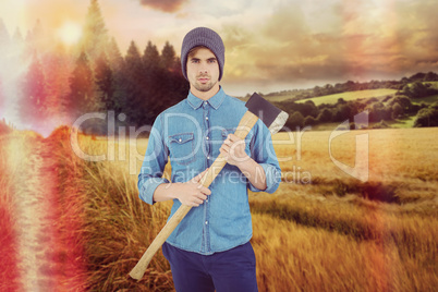 Composite image of portrait of serious hipster holding axe