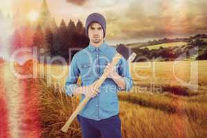 Composite image of portrait of serious hipster holding axe