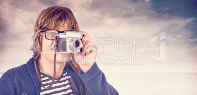 Composite image of hipster taking pictures with an old camera