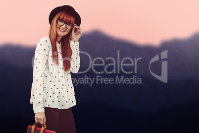 Composite image of smiling hipster woman holding book belt