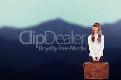 Composite image of smiling hipster woman holding suitcase