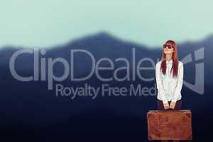 Composite image of smiling hipster woman holding suitcase