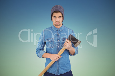 Composite image of serious hipster wearing knitted hat holding a