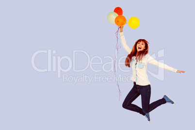 Composite image of smiling hipster woman holding balloons