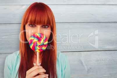 Composite image of smiling hipster woman with a lollipop