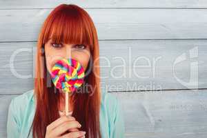 Composite image of smiling hipster woman with a lollipop