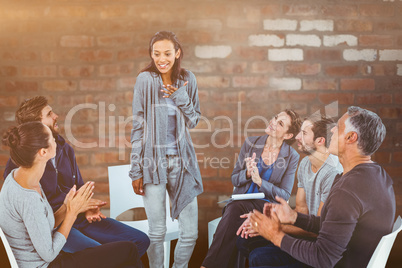 Composite image of  rehab group applauding delighted woman stand