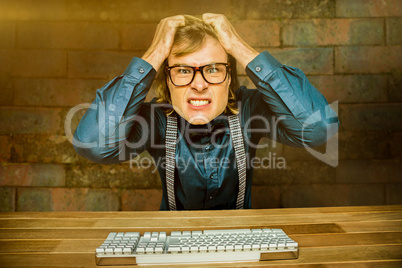 Composite image of angry hipster businessman holding his hairs
