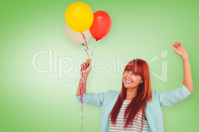 Composite image of smiling hipster woman holding balloons