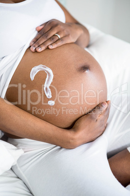 Pregnant woman applying cream on her belly