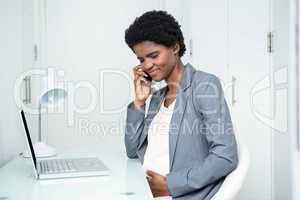 Pregnant businesswoman on the phone