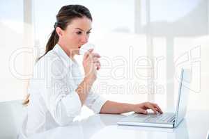 woman drinking a coffee and typing