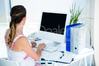 pregnant business woman typing on her computer