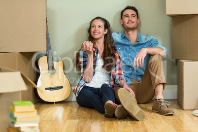 Young couple sitting together on the floor and smiling