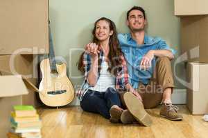 Young couple sitting together on the floor and smiling