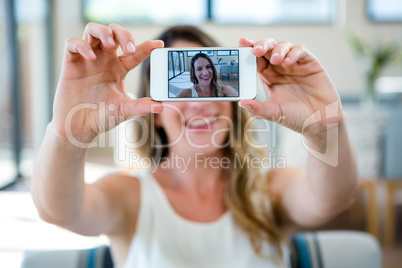 smiling woman taking a selfie on her mobile phone