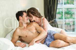 Young couple cuddling on bed