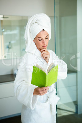 woman in a dressing gown reading a book