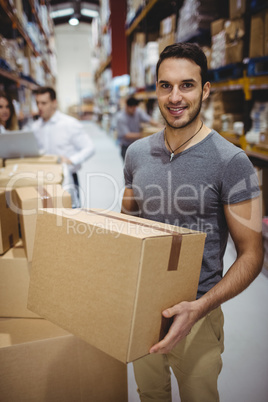 Smiling man carrying box