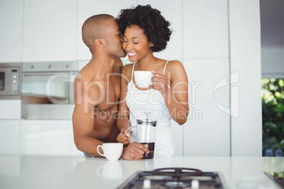 Happy couple drinking coffee in the kitchen