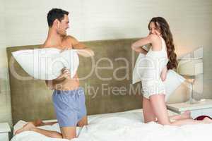 Young couple playing pillow fight