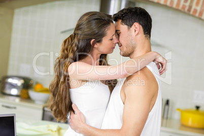 Young couple cuddling in kitchen
