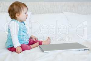 adorable baby playing with a laptop