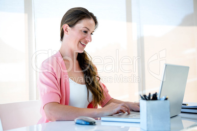 smiling buwiness woman typing on her laptop
