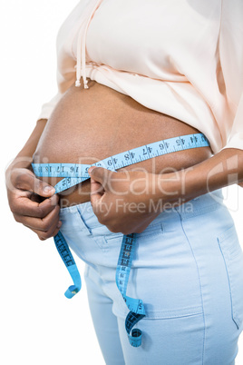 Pregnant woman measuring her belly