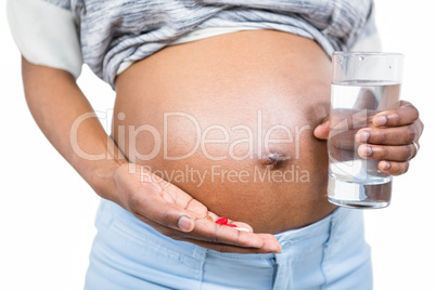 Pregnant woman with water and pills
