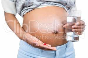 Pregnant woman with water and pills