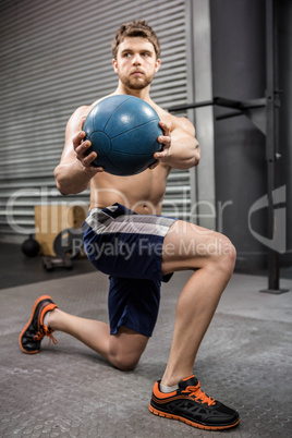 Shirtless man training with medicine ball