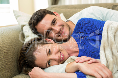 Portrait of young couple lying together on sofa