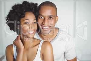 Portrait of smiling couple in bedroom