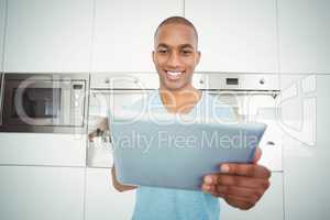 Smiling man using tablet in the kitchen