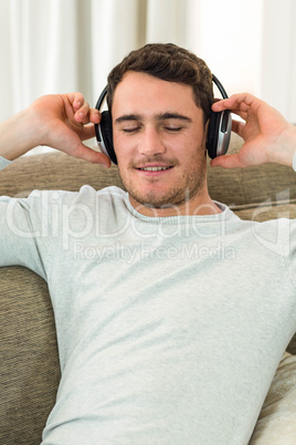 Young man feeling relaxed while listening to music