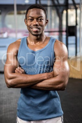 Muscular man standing with arms crossed