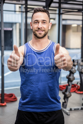 Muscular man showing thumbs up