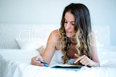 woman on her tablet holding her credit card