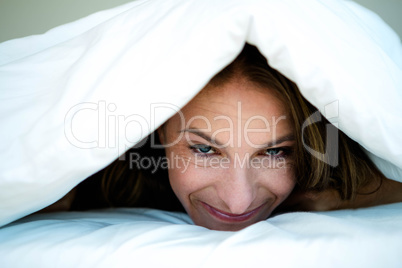 woman peering out from under her duvet