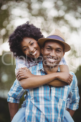 Handsome man giving piggy back to his girlfriend