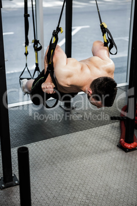 Shirtless man hanging at the rope