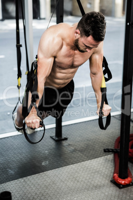 Shirtless man hanging at the rope