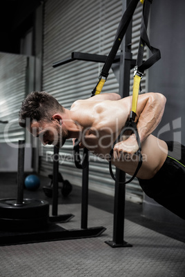 Shirtless man hanging at the rope