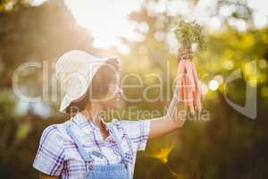 Smiling woman holding carrots