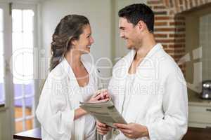 Happy couple in bathrobe reading newspaper