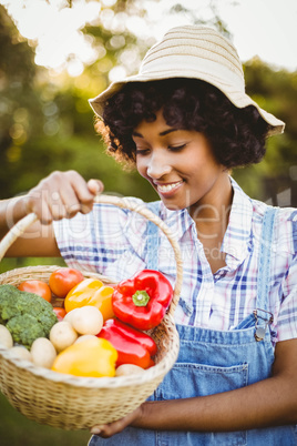 Smiling woman looking at basket of vegetables